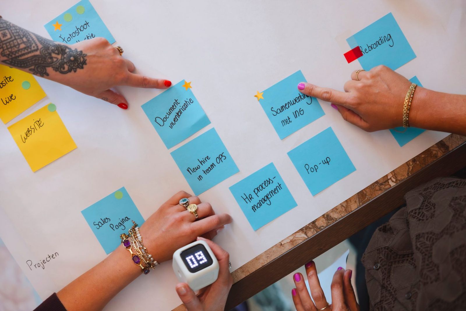 Handen schuiven post-its met prioriteiten op volgorde